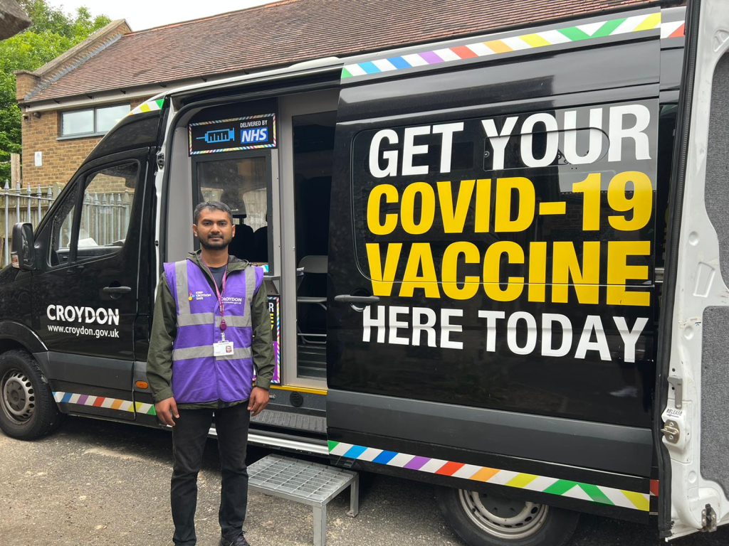 A vaccinator stands outside the Croydon vaccination van