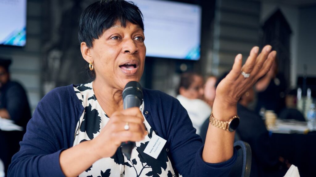 Female care home manager speaking to microphone at kidney care event