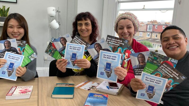 Four people hold up leaflets about winter wellbeing to promote the Winter Engagement Fund grant applications