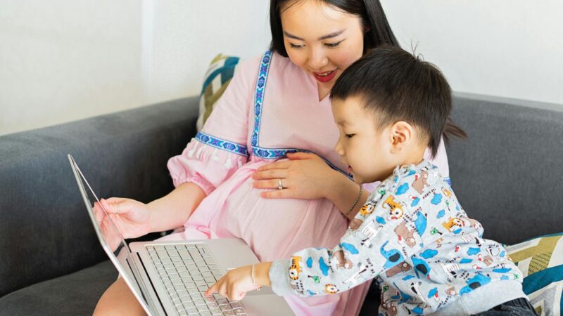 pregnant mum with little boy look at computer